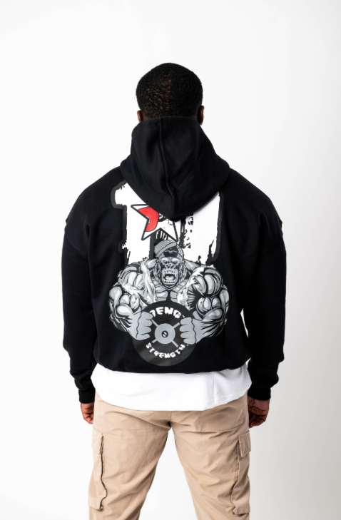 Person wearing a black hoodie with a graphic design on the back, standing against a white background